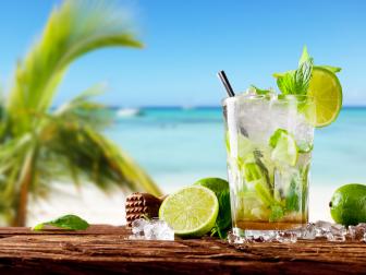 Mojito drink on wood with blur beach background